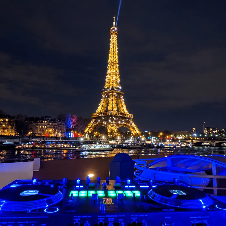 Platines DJ face à la tour Eiffel illuminée